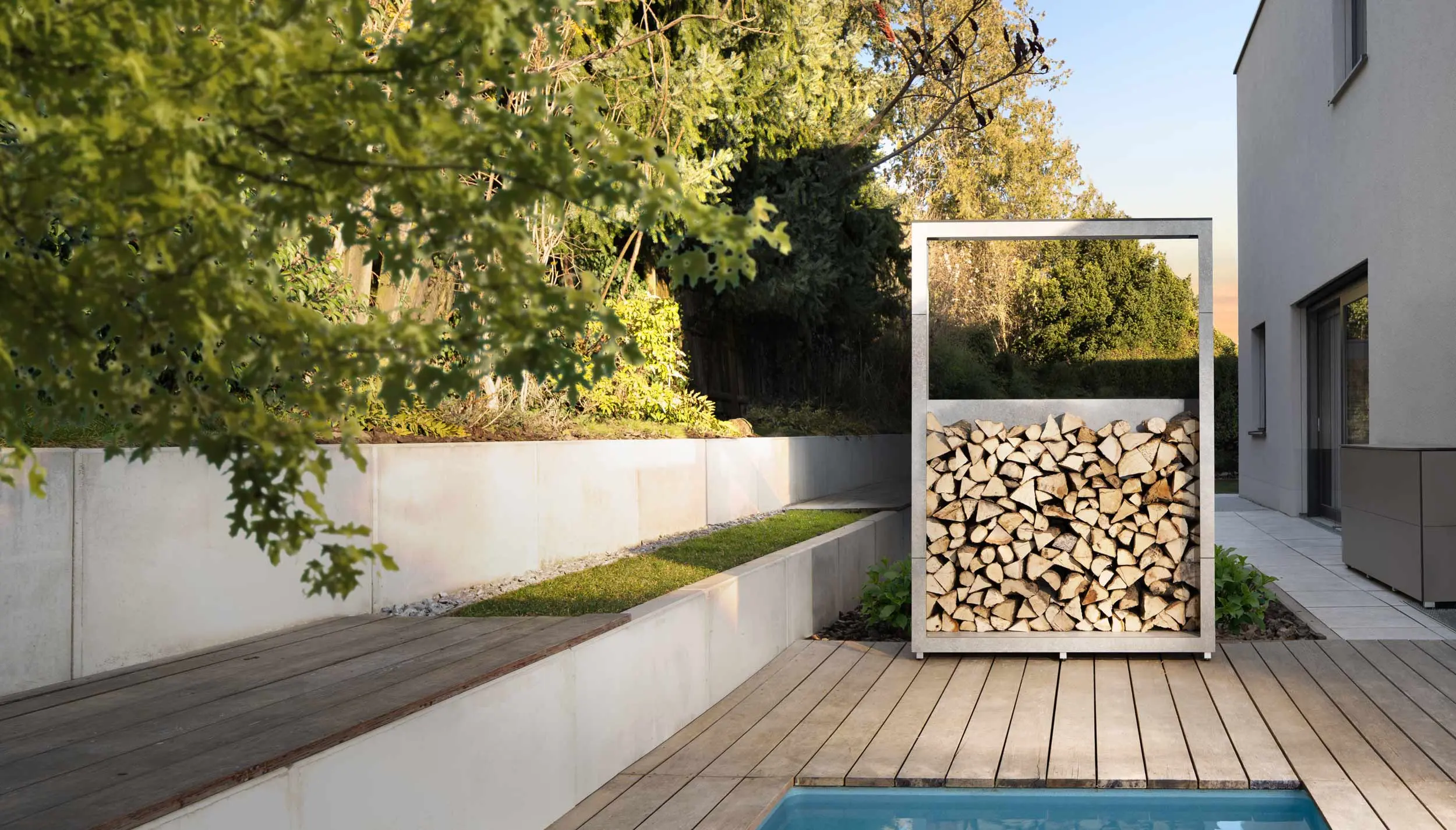 Modernes Holzlager als Sichtschutz und Raumteiler im Garten – kubisches Design aus HPL
