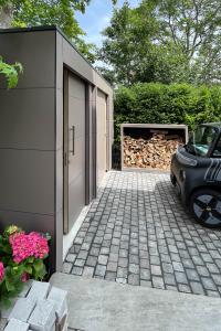 A perfect trio: wood storage, garden shed and bin storage unit