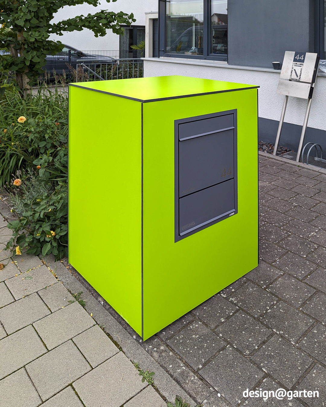 Grüne Mülltonnenbox mit separater Paketbox und Briefkasten