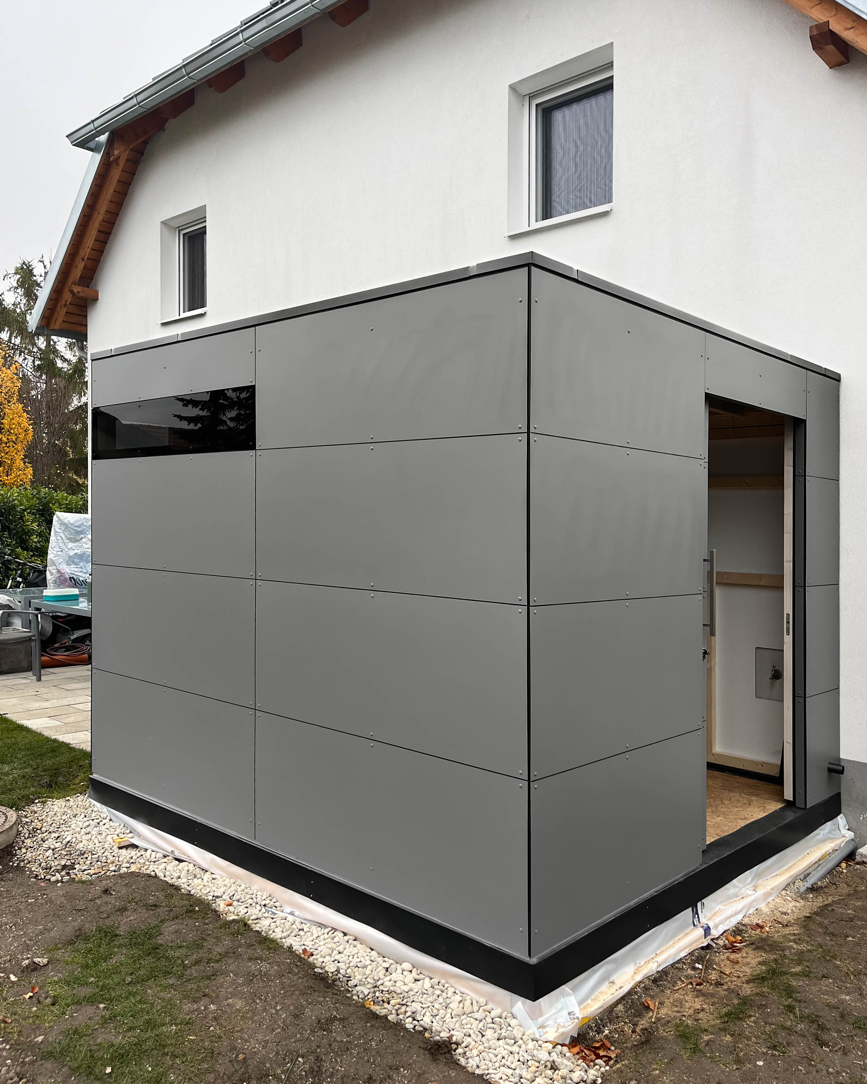 Modernes Gartenhaus mit Durchgang in matt grau mit Eckverglasung