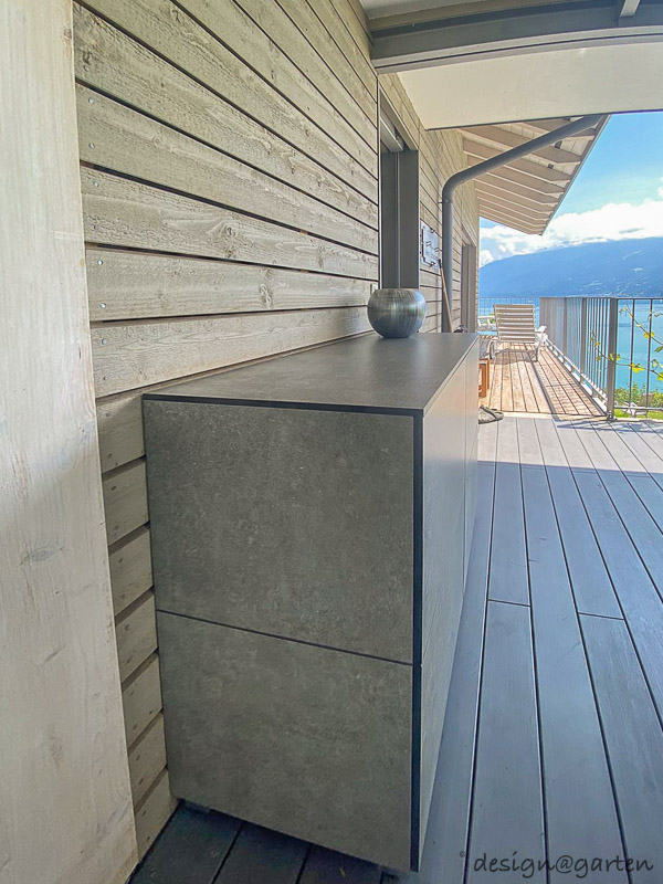 Small weatherproof patio cabinet as a sideboard with a view of Lake Thun