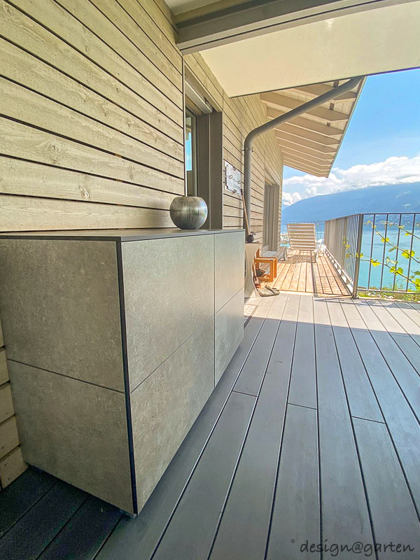 Small weatherproof patio cabinet as a sideboard with a view of Lake Thun