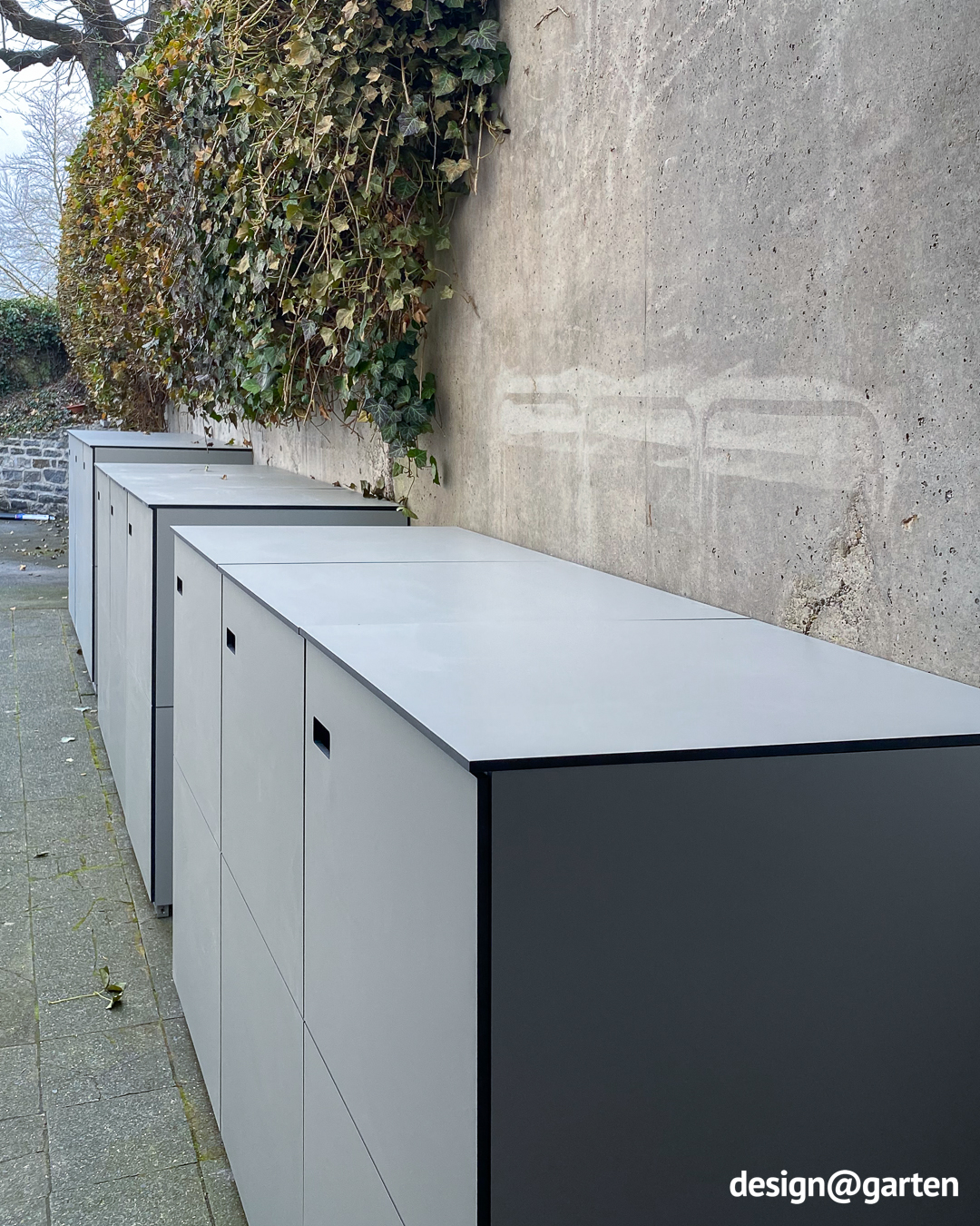 Three 3-bin waste bin enclosures in light grey made of HPL