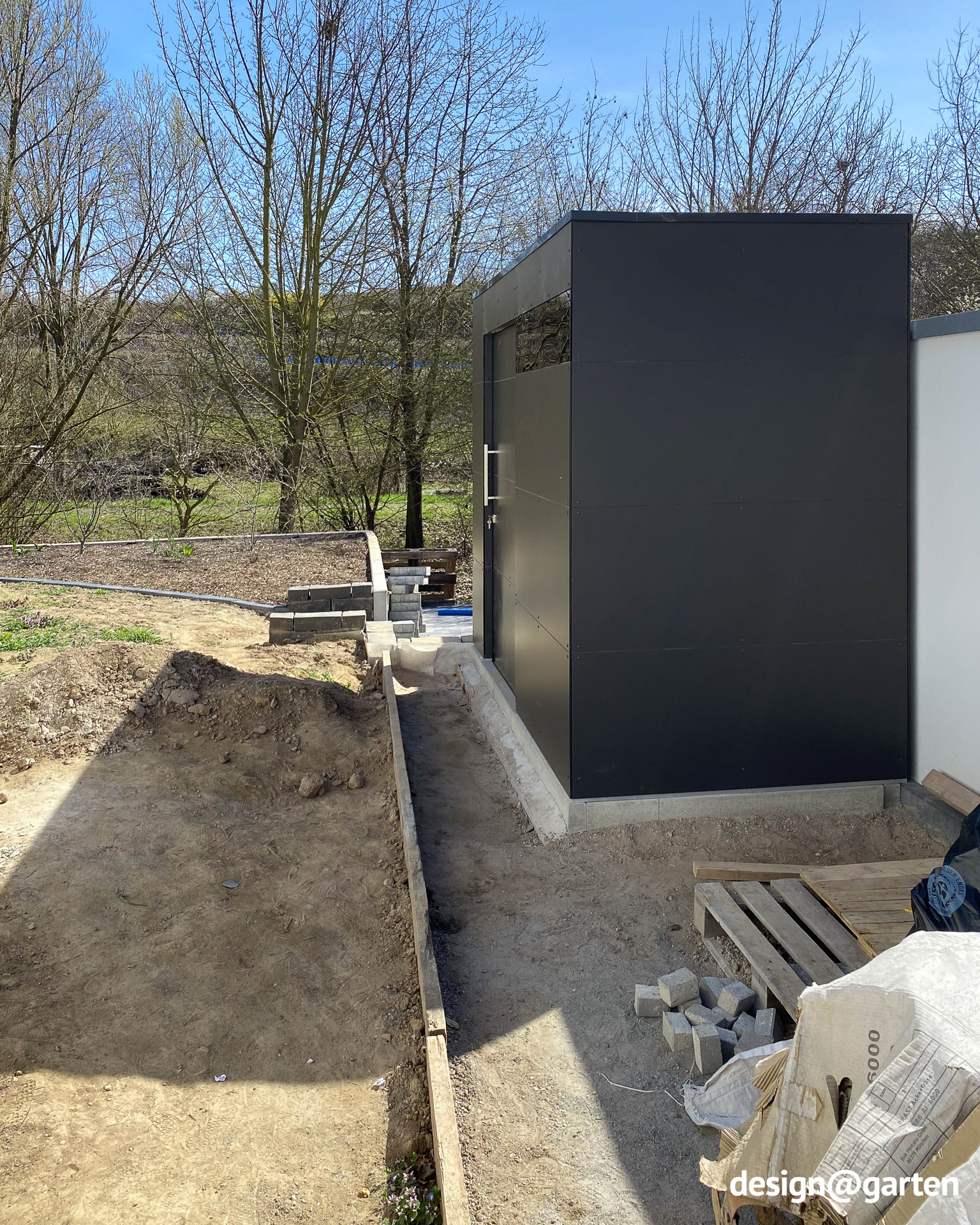 Garden shed in anthracite with a flat roof next to the garage