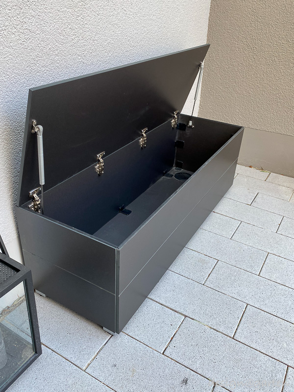 Caja de jardín con función de asiento como solución elegante para la zona de entrada