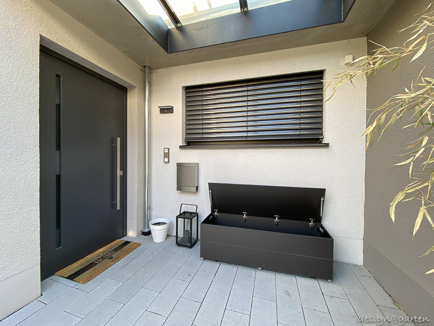 Caja de jardín con función de asiento como solución elegante para la zona de entrada