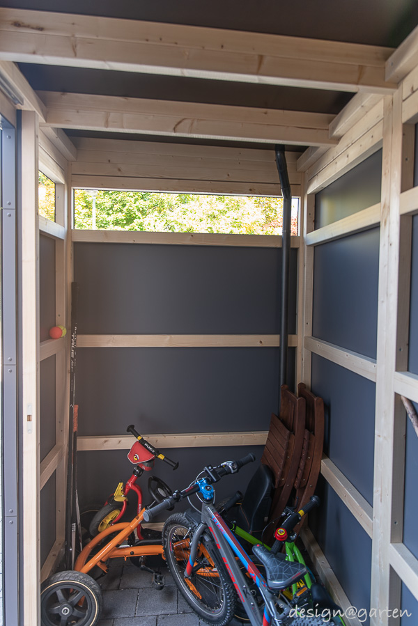 Cobertizo rectilíneo en el jardín delantero como moderno garaje para bicicletas