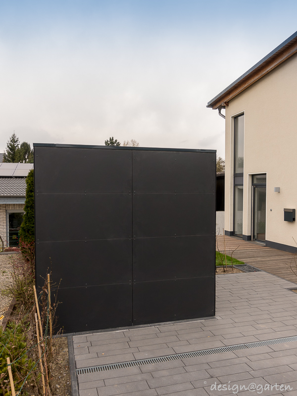 Symétrie dans l'allée : l'abri de jardin angulaire avec toit plat