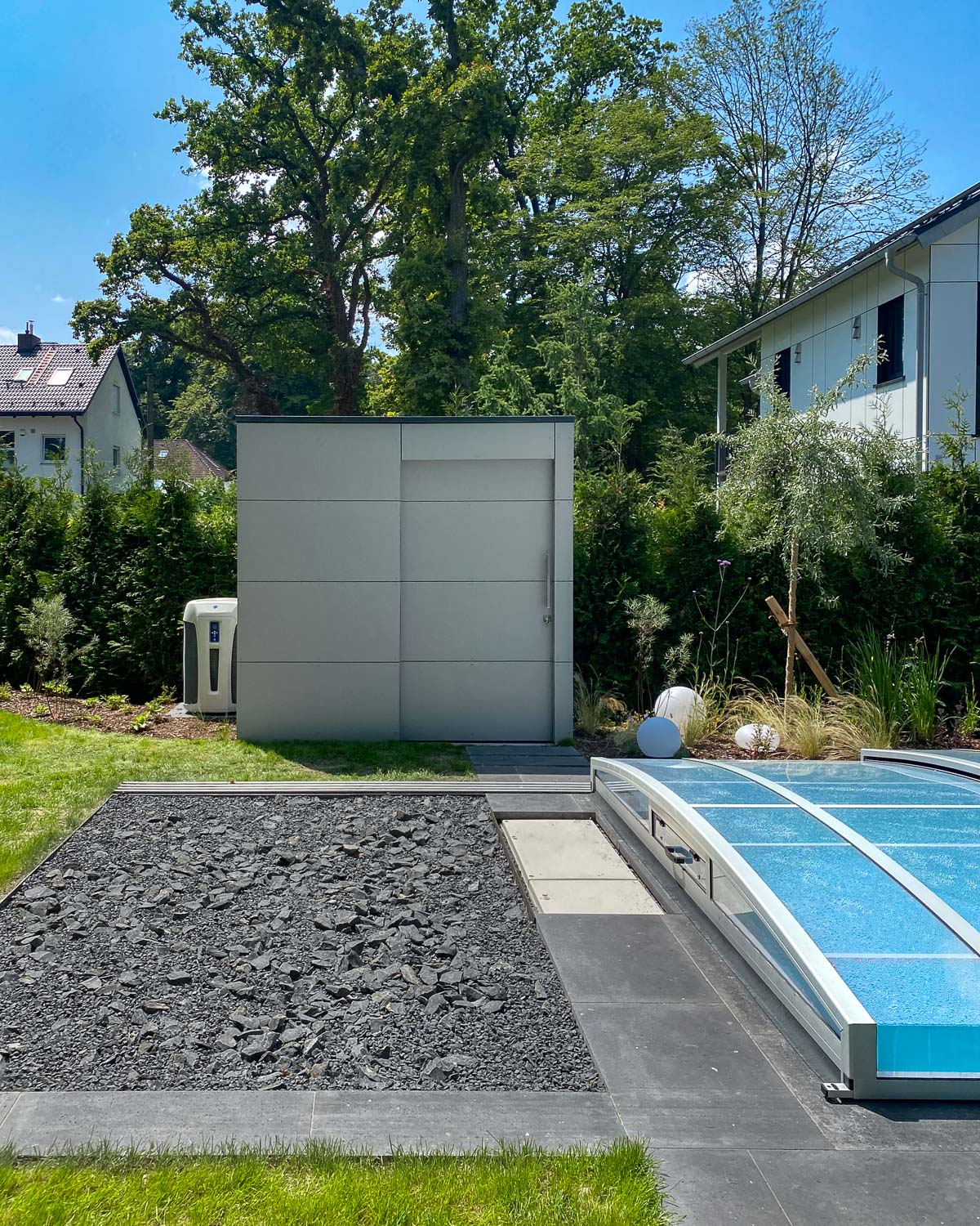 Pool house moderne avec porte coulissante servant espace de rangement et abritant les équipements techniques de la piscine