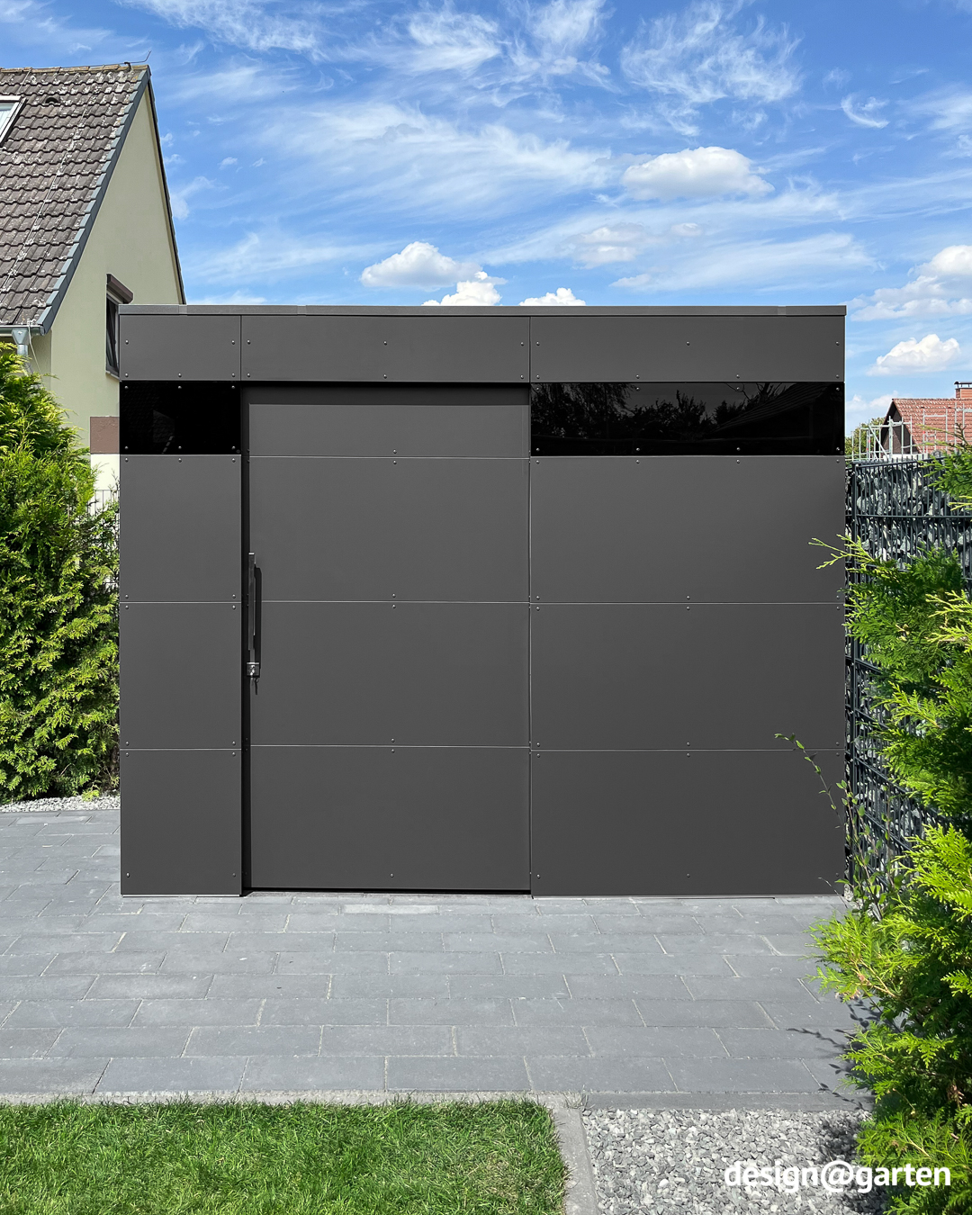 Remise à outils anthracite dans le coin du terrain