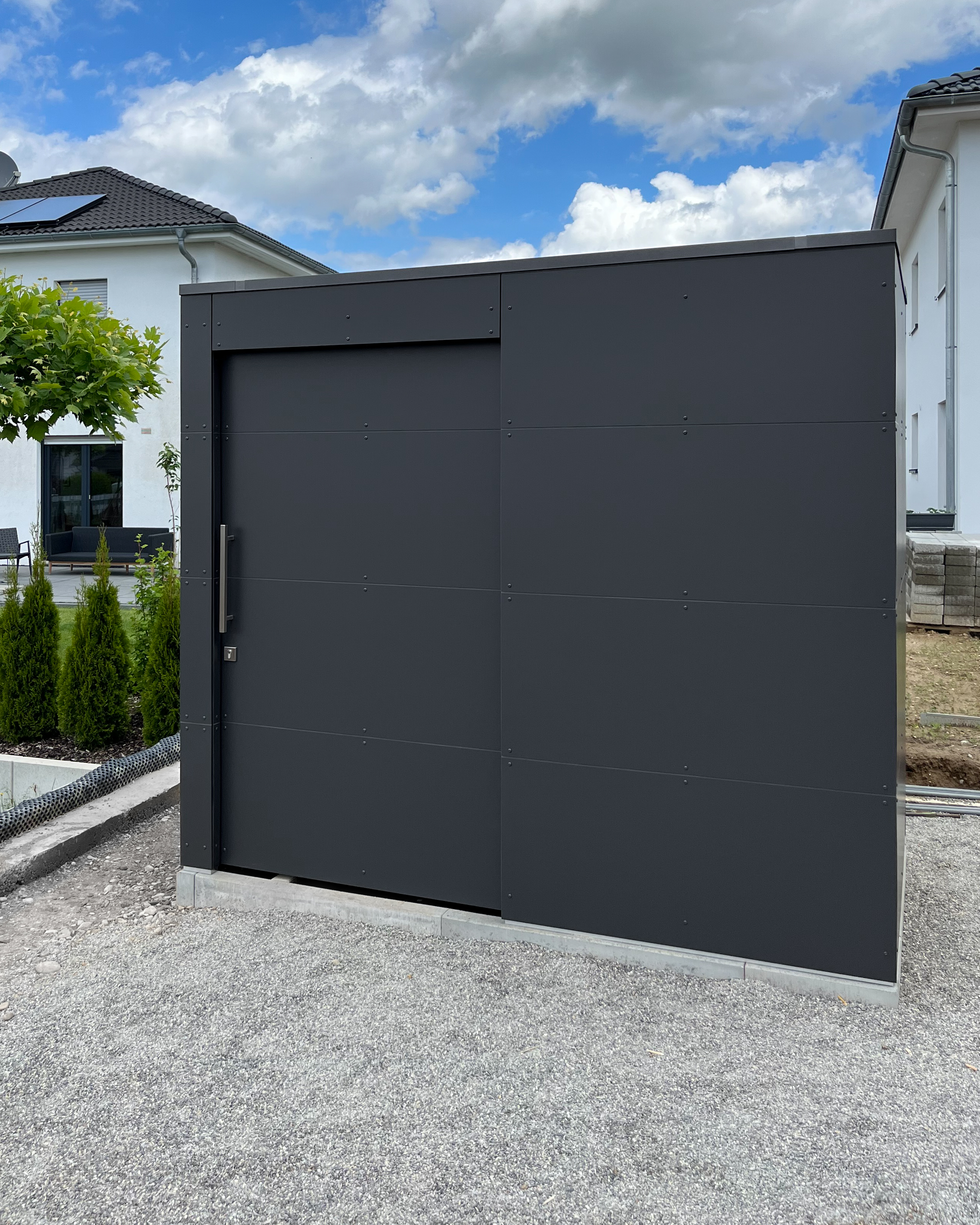 Abri de jardin anthracite dans le fond du jardin