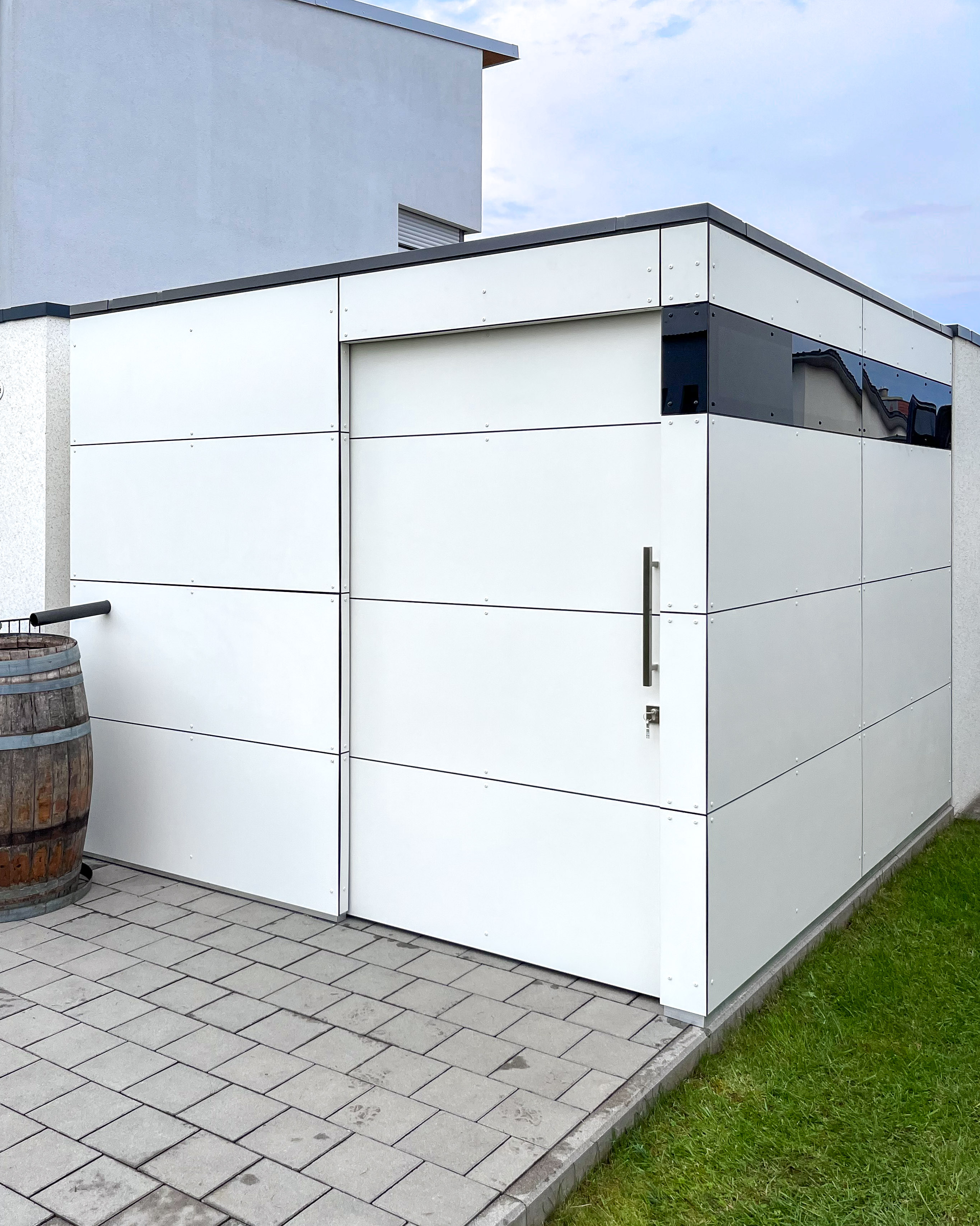 Espace de rangement à côté du garage avec abri de jardin blanc