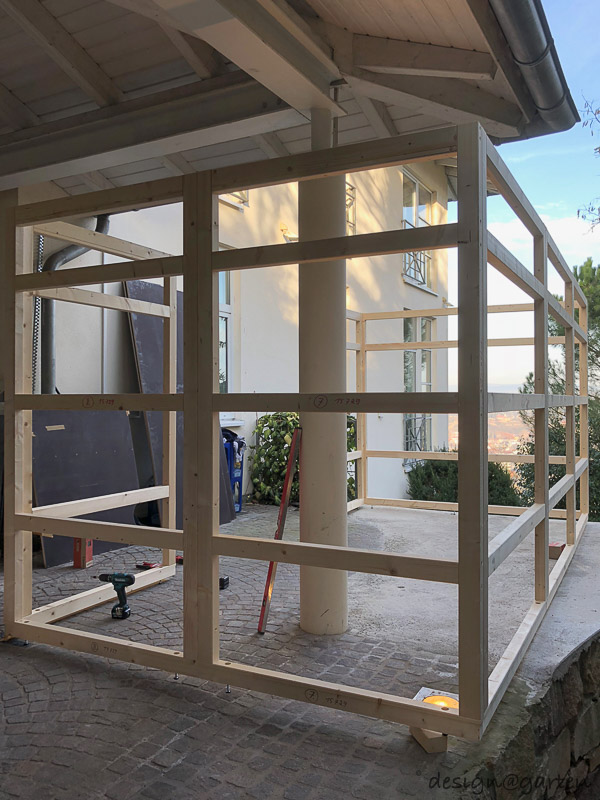 Lavoro su misura sotto il posto auto coperto: la casetta da giardino di design come miracolo di integrazione