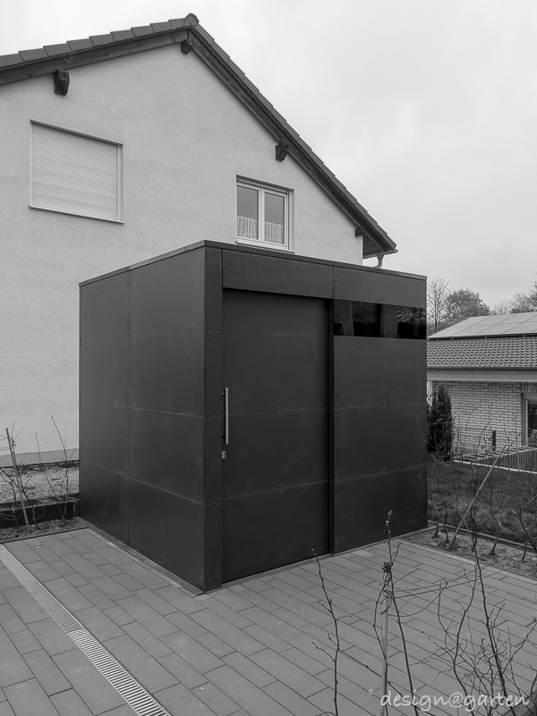 Simmetria nell'ingresso: la casetta da giardino angolare con tetto piano