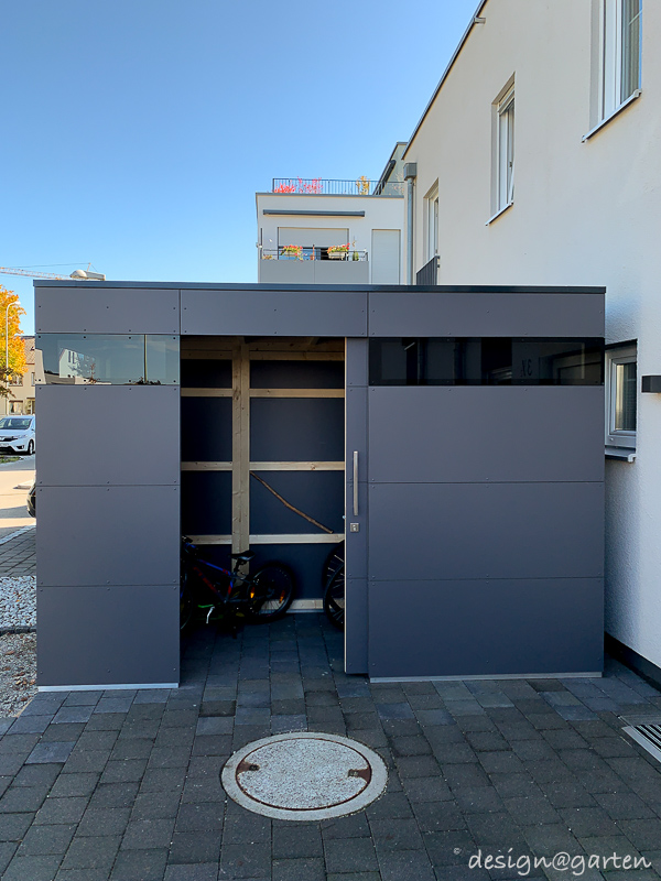 Casetta lineare nel giardino anteriore come moderno garage per biciclette