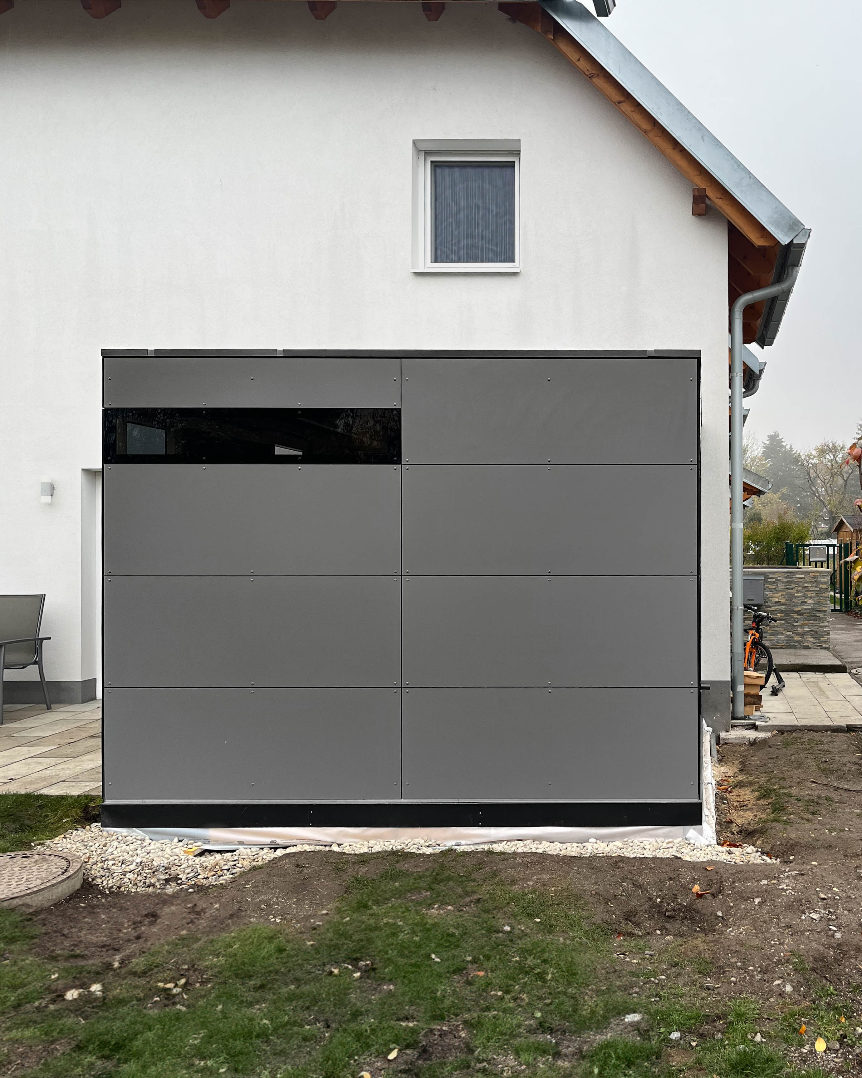 Moderna casetta da giardino con passaggio in grigio opaco con vetrata angolare